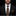 Man wearing a black suit with a patterned tie and pocket square on a black background
