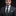 Man wearing a dark suit with a green patterned tie against a black background