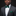 Man wearing a gray suit with a green bow tie and pocket square on a black background