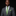 Man wearing a gray suit with a green tie and pocket square on a black background