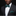 Man wearing a black suit with a green bow tie and pocket square against a dark background