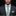 Man wearing a gray suit with a green and blue paisley tie and pocket square on a black background
