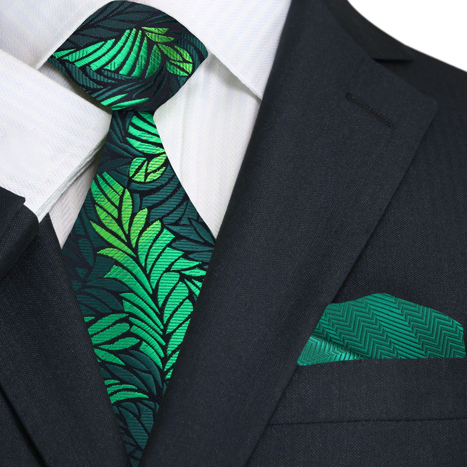 Green leaf-patterned tie and matching pocket square on a black suit jacket.