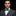 Man wearing a gray suit with a green bow tie on a black background