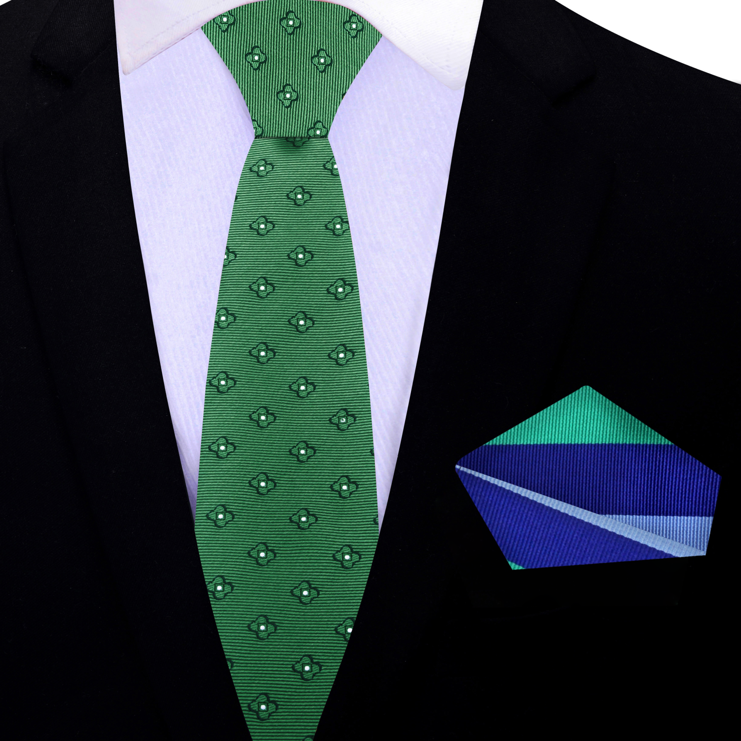 Green patterned tie and stripe pocket square on a black suit jacket.
