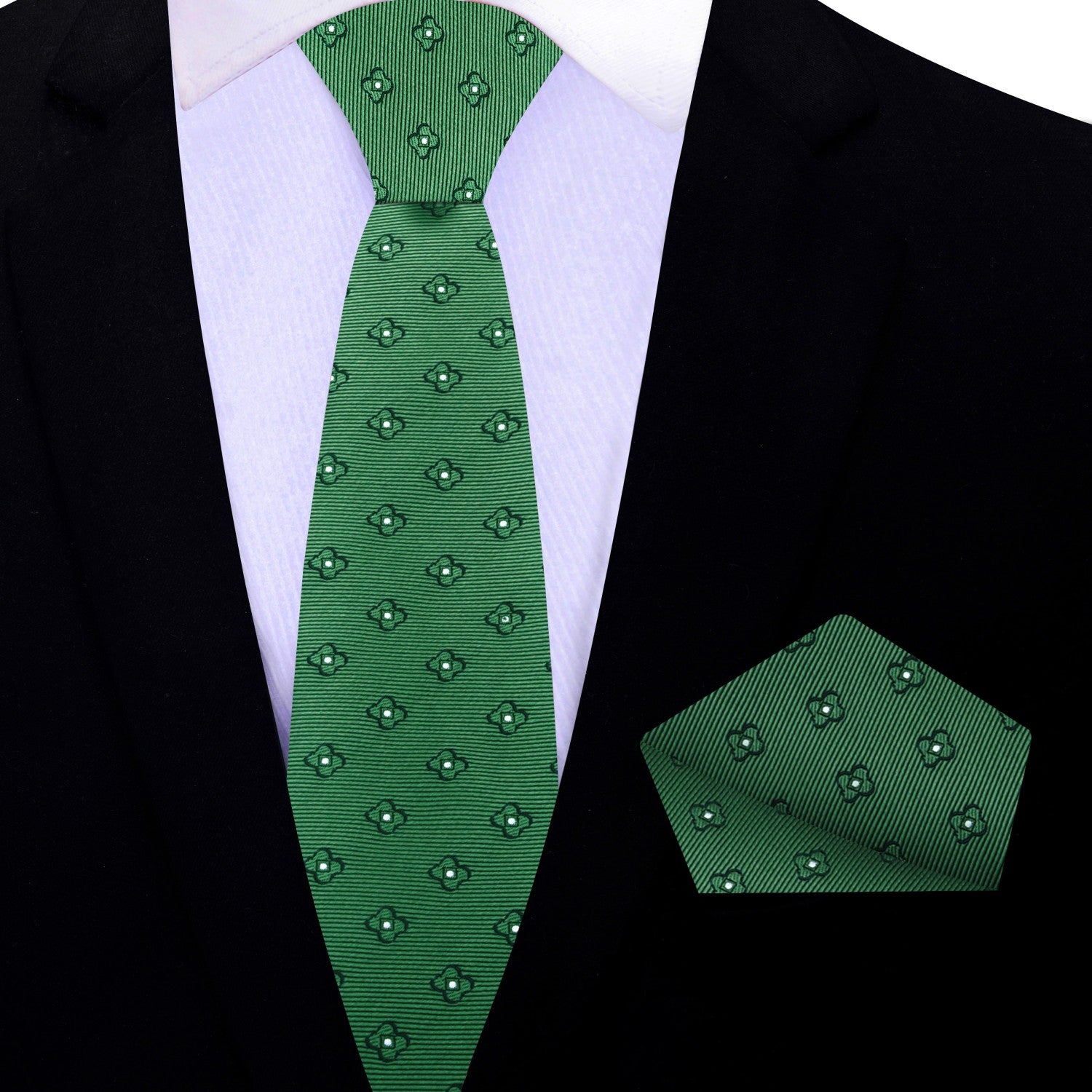 Green patterned tie and matching pocket square on a black suit jacket.