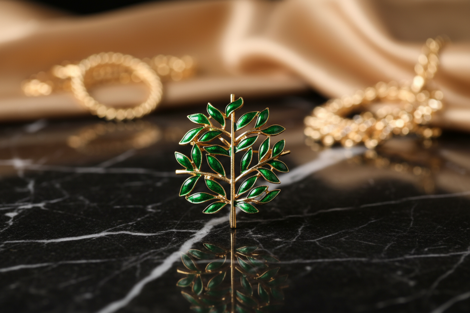 An olive leaves lapel pin with green leaves and gold-colored stem and branches, placed on a wooden surface with blurred flowers in the background.