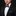Man wearing a black suit with a colorful bow tie and matching pocket square on a black background