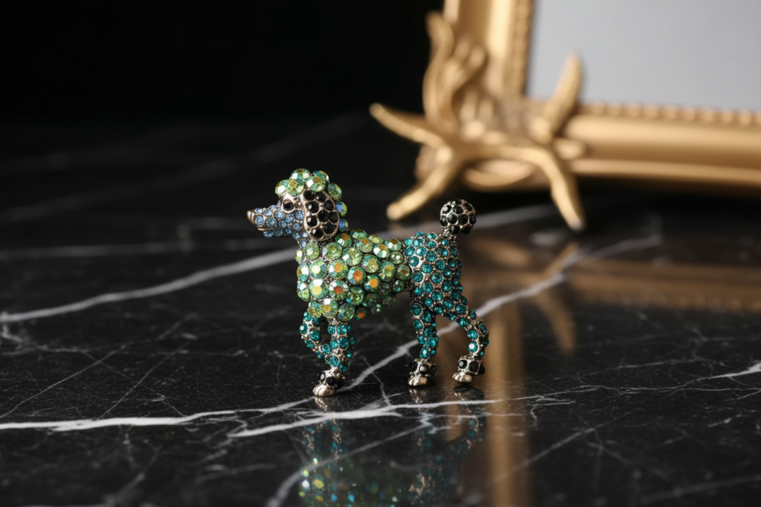 Decorative brooch shaped like a dog with green and blue gemstones 