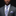 Man wearing a gray suit with a floral tie and pocket square on a black background