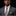 Man wearing a gray suit with a colorful plaid tie and pocket square on a black background