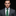 Man wearing a gray suit with a green paisley tie and pocket square on a black background