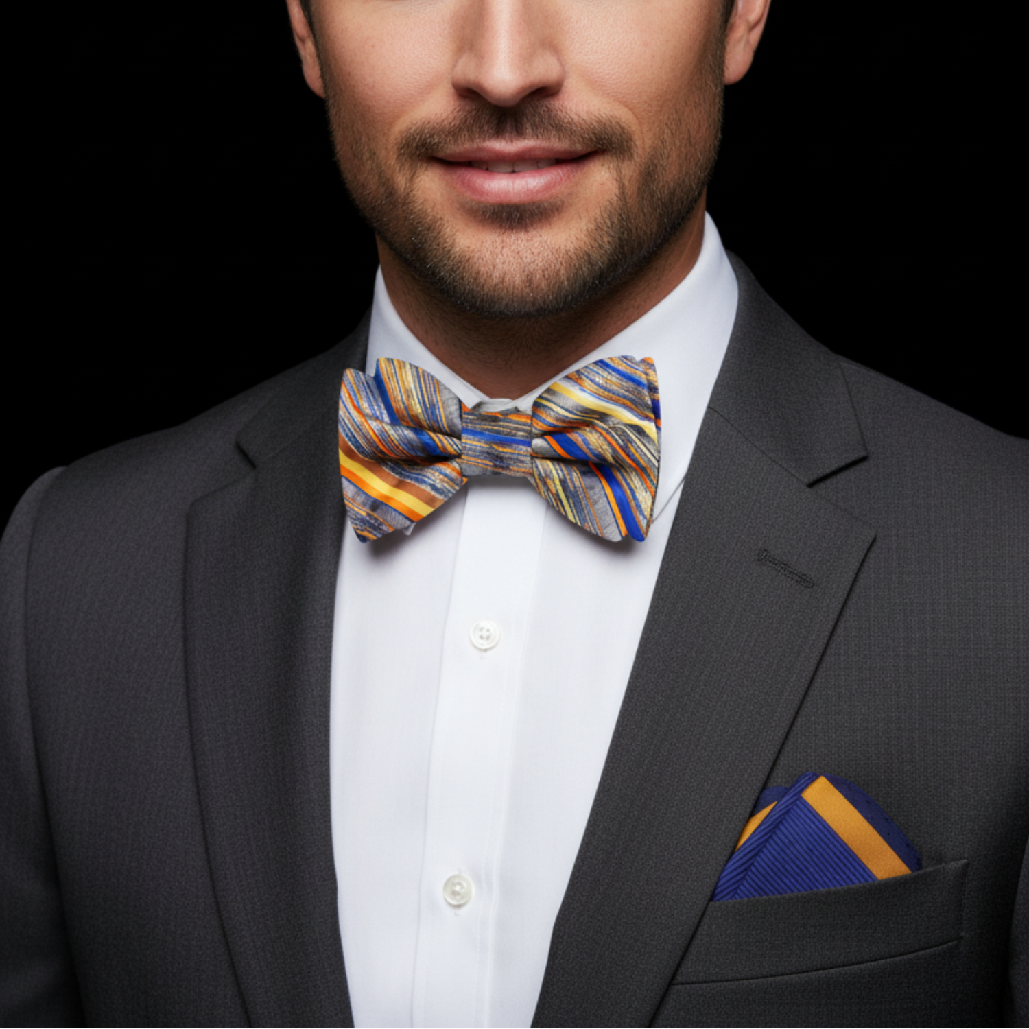 Man wearing grey blue and gold stripe bow tie and accenting square on suit