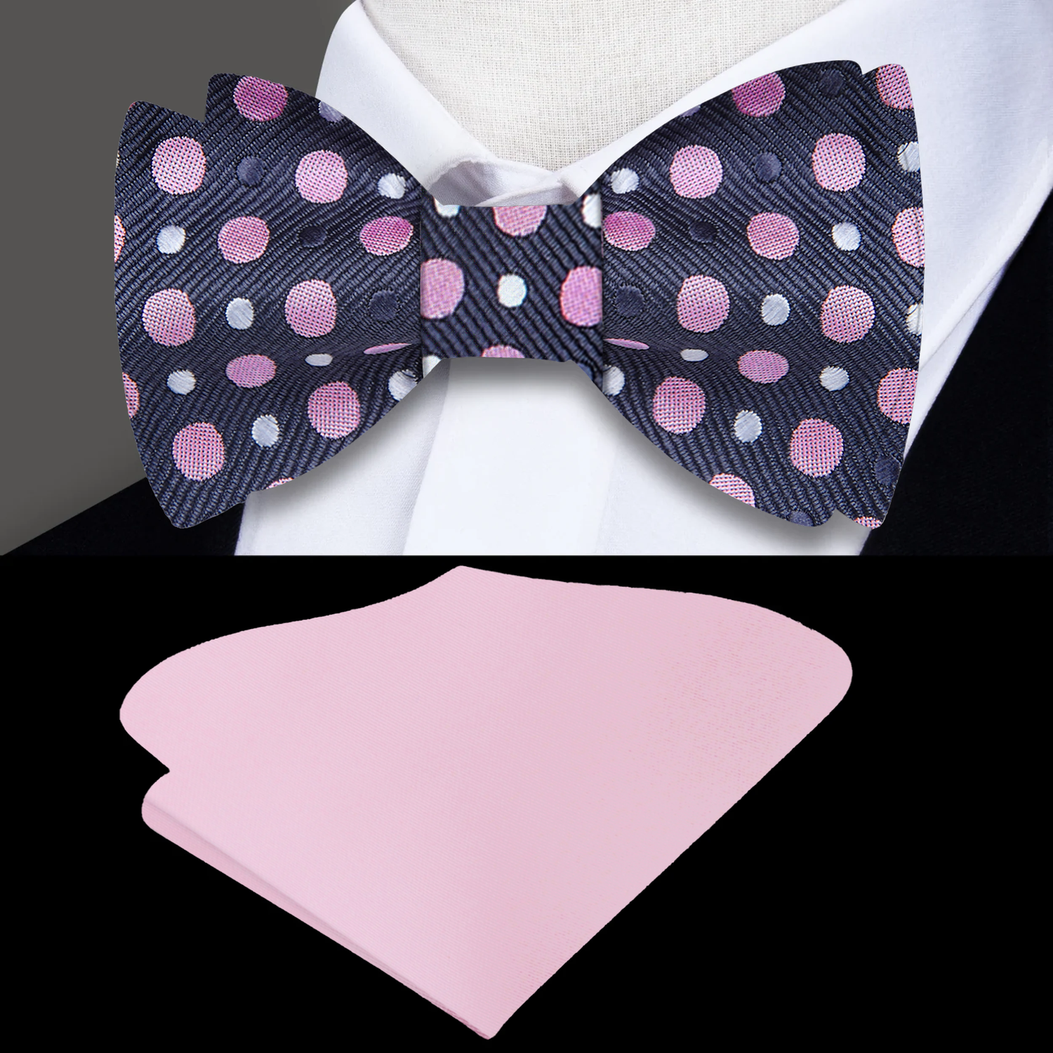 A polka dot silk bow tie in gray, pink, and white displayed on a white shirt, paired with a pink pocket square.