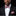 Man wearing a black suit with a red and white patterned bow tie and pocket square on a black background