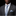 Man wearing a gray suit with a blue patterned tie and pocket square on a black background