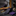 Black belt with purple accents on a marble surface next to a gold pen and decorative items.
