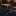 Black tie with purple accents on a dark marble surface, with a blurred background of a store setting.