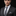 Man wearing a dark suit with a gray striped tie against a black background
