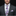 Man wearing a gray suit with a floral tie and pocket square on a black background