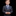 Young boy in a gray suit with a blue tie and pocket square on a black background
