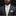 Man wearing a gray suit with a polka dot tie and pocket square against a black background