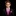 A young boy wearing a black suit jacket, white dress shirt, bright pink tie, and matching pink pocket square, photographed against a solid black background.