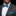 Man wearing a gray suit with a blue patterned bow tie and pocket square on a black background