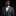 Man wearing a gray suit with a blue bow tie and pocket square on a black background