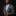 Man wearing a gray suit with a patterned tie and blue pocket square on a black background