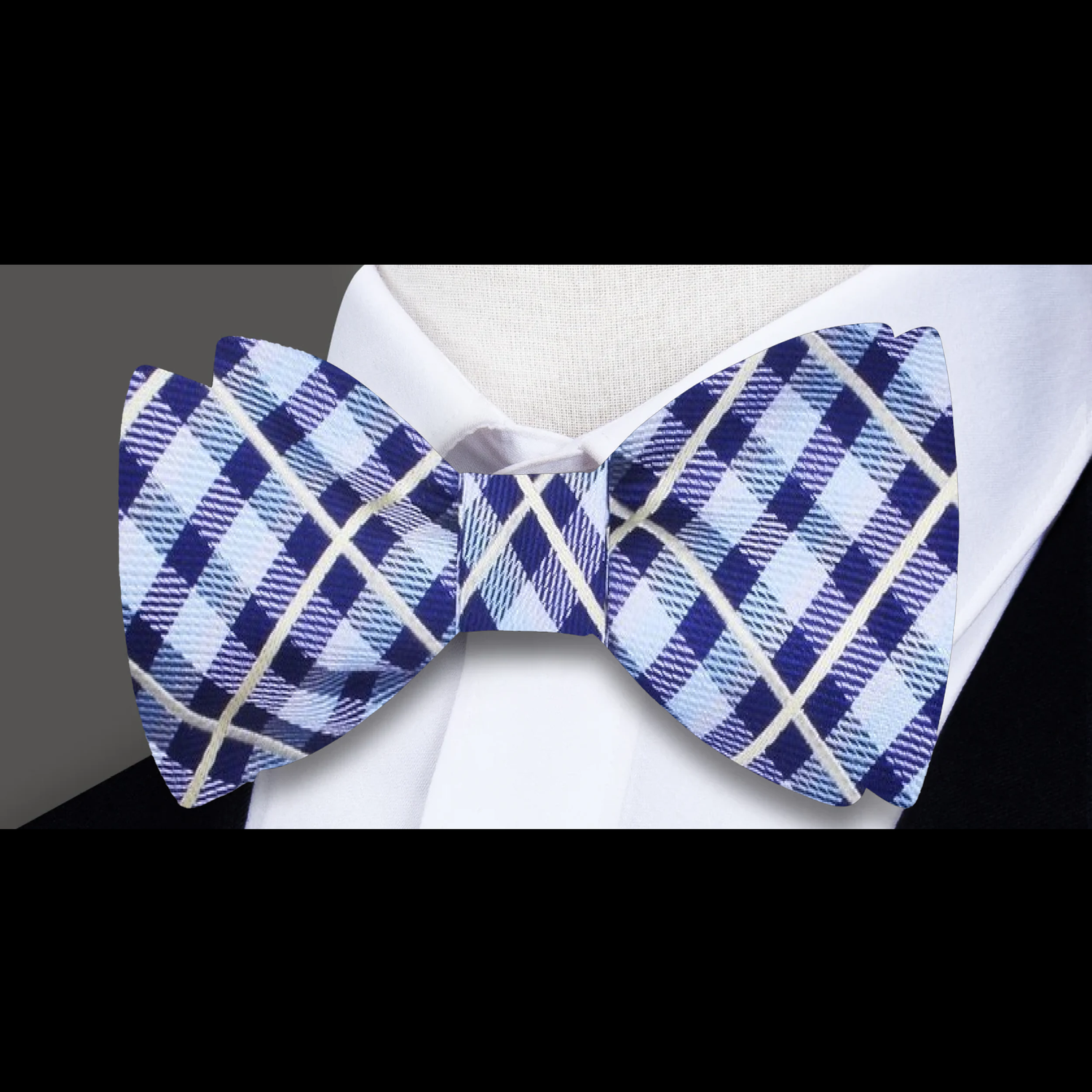 A plaid patterned bow tie in shades of blue and yellow, displayed on a white background with a solid blue pocket square.