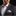Man wearing a gray suit with a patterned pocket square on a black background