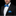 Man wearing a black tuxedo with a blue bow tie and pocket square on a black background