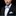 Man wearing a black suit with a blue bow tie and pocket square on a black background