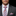 Man wearing a gray suit with a blue and orange striped tie and pocket square.