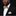 Man wearing a black suit with a gold bow tie and pocket square against a dark background