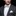 Man wearing a gray suit with a beige bow tie and pocket square on a black background