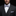 Man wearing a black suit with a white shirt and purple bow tie and pocket square on a dark background