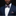 Man wearing a navy suit with a floral bow tie and pocket square on a black background