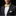 Man wearing a black suit with a yellow bow tie on a dark background
