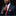 Man adjusting a red tie with a dark suit and black background