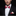 Man wearing a black tuxedo with a red and white bow tie and matching pocket square on a black background.