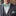 Man wearing a gray suit with a white shirt, green bow tie, and matching pocket square.