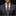 Man wearing a gray suit with a colorful floral tie and pocket square on a black background