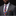 Man wearing a gray suit with a colorful checkered tie against a black background