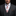Man wearing a gray suit with a white shirt, red patterned tie, and plaid pocket square on a black background.
