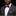Man wearing a gray suit with an orange and blue bow tie and pocket square on a black background