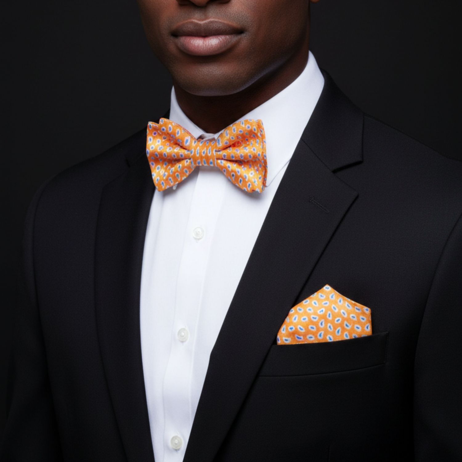 man with suit wearing orange blue paisley now tie and square