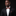 Man wearing a black suit with a colorful bow tie and pocket square on a dark background