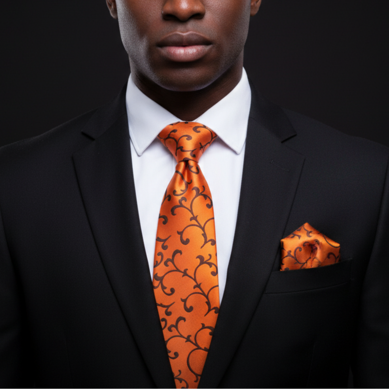 Man wearing orange and brown vines tie and square 